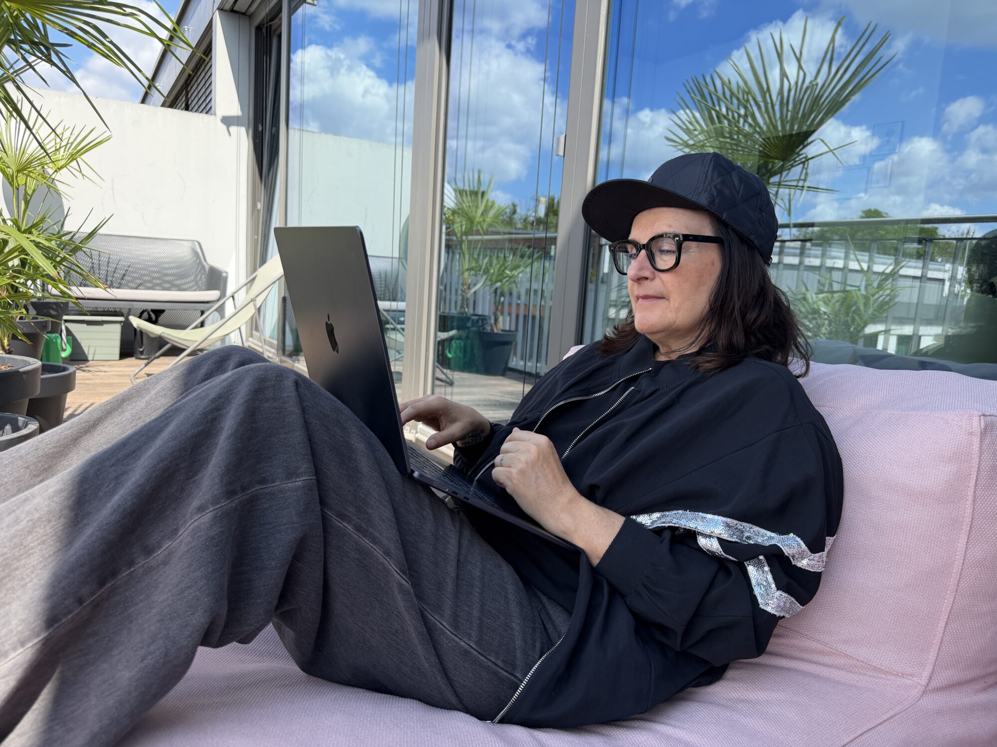 Anja Maria Welzel mit Laptop auf einer Terrasse